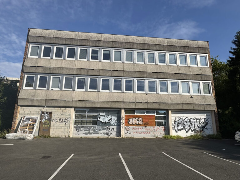 Vue extérieure de la façade taguée et dégradée de l'ancien immeuble de bureaux